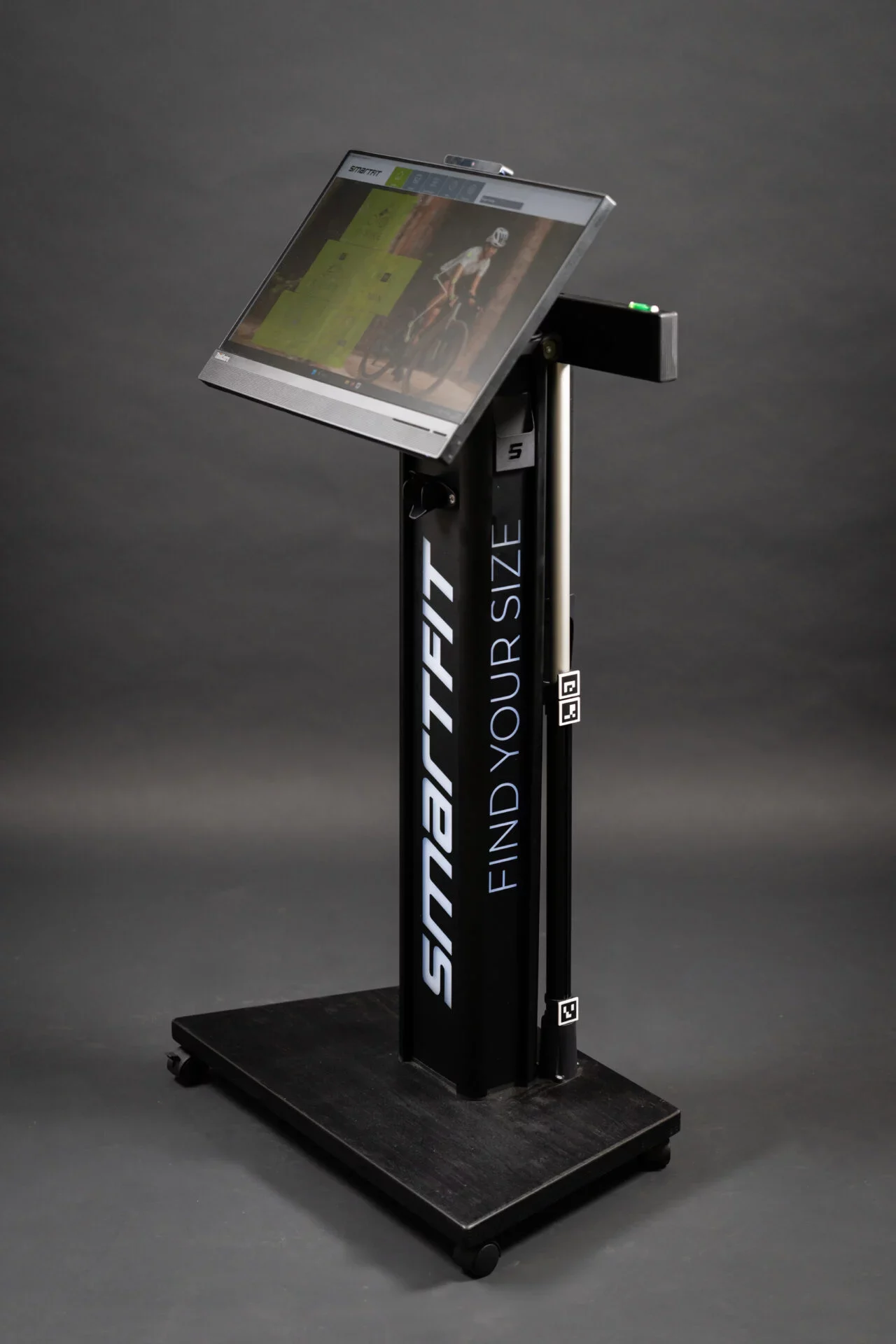 Stehendes Messgerät mit Bildschirm und der Aufschrift 'SMARTFIT FIND YOUR SIZE' auf schwarzem Sockel.